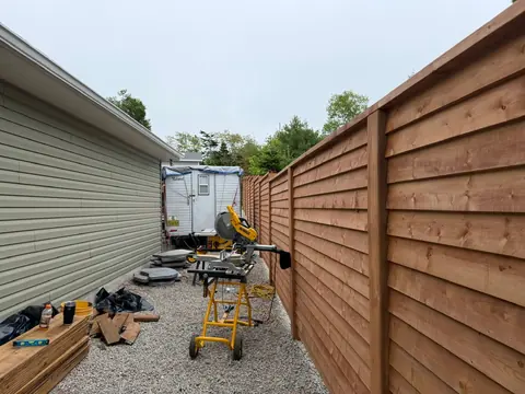 Wood fence replacement detail with boards and tools on site