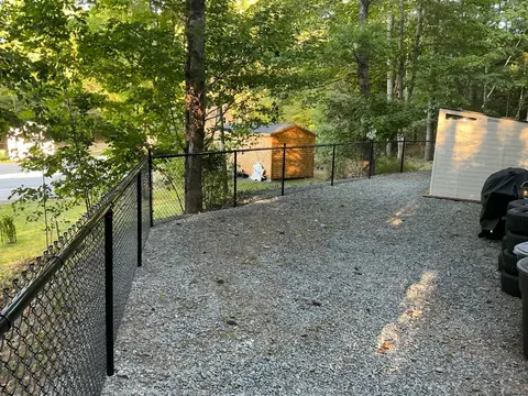 Black chain-link fencing around a gravel yard