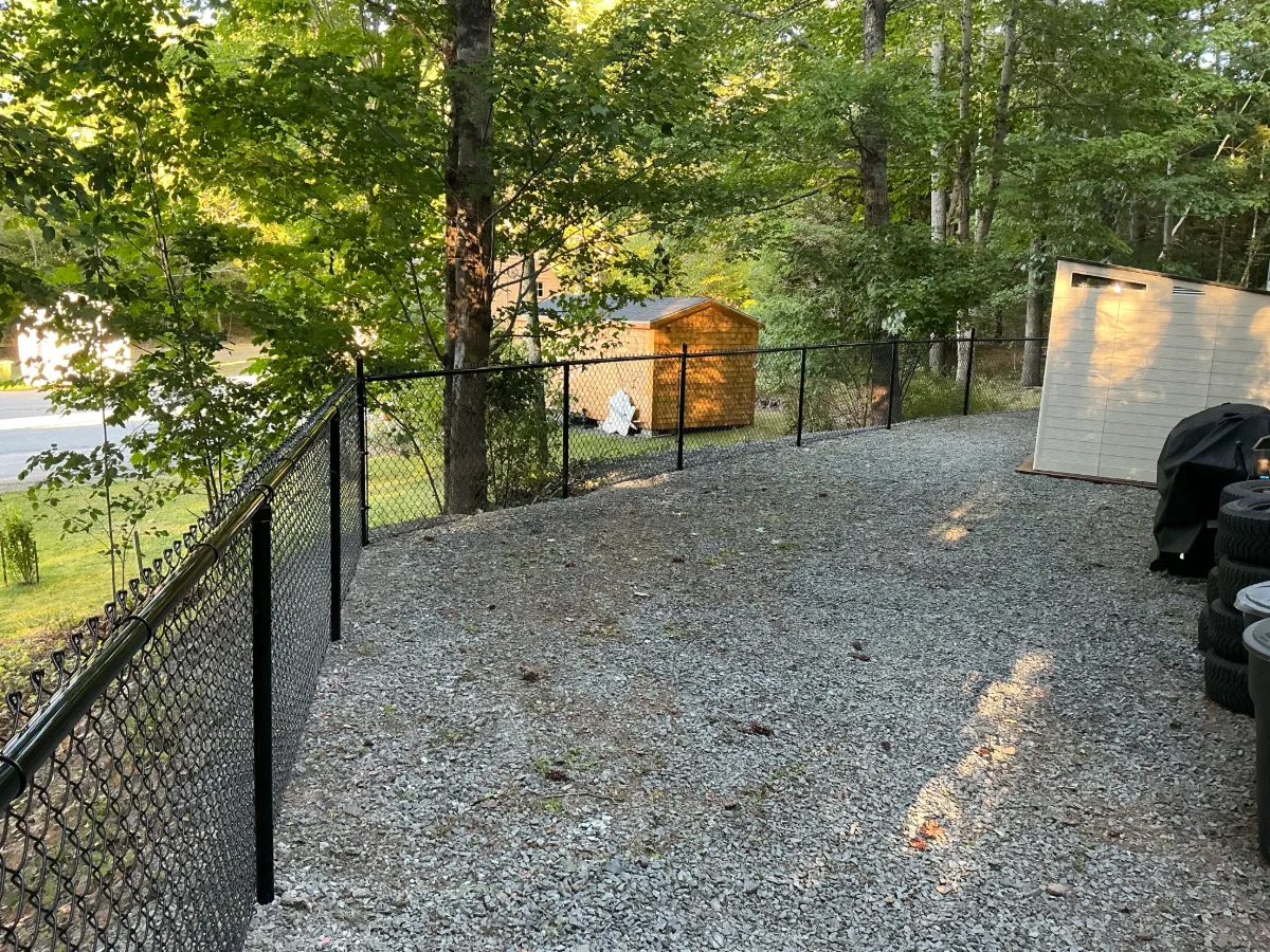 Black chain-link fencing around a gravel yard