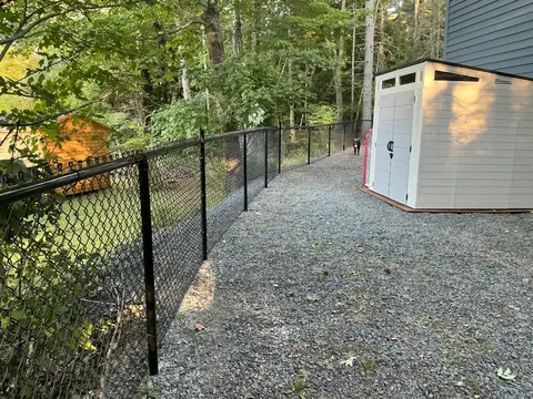 Chain-link fence beside a storage shed