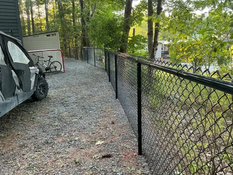 Black chain-link fence along a gravel path