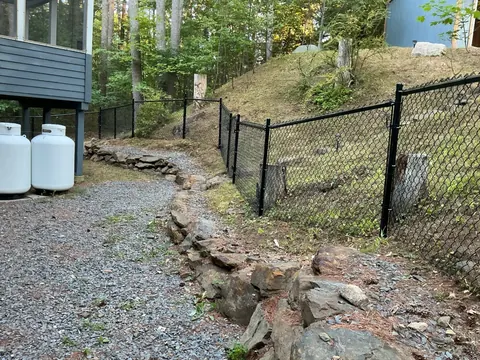 Chain-link fence and gate around a rocky yard