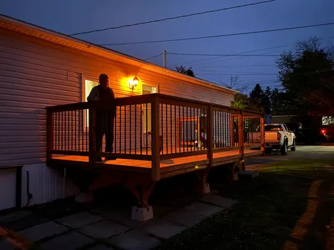 Wood deck railing lit at dusk