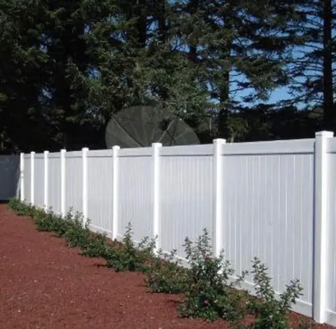 White privacy fence along a landscaped edge