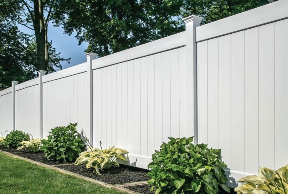 White vinyl privacy fence with landscaping
