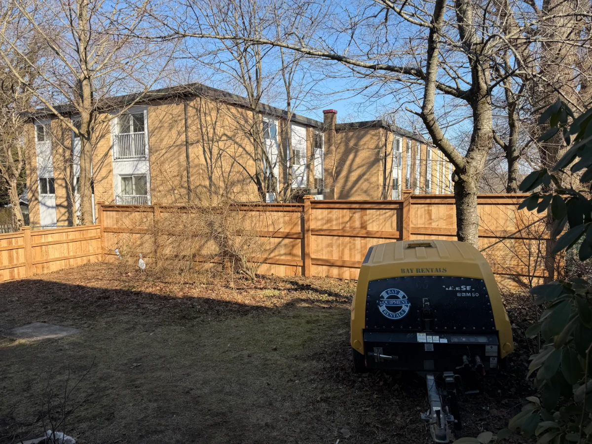Wood fence installation behind a property