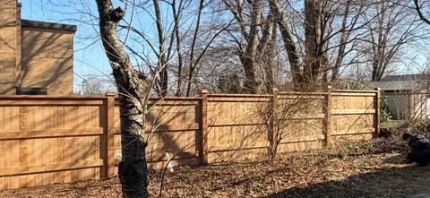 Wide wood fence line behind trees
