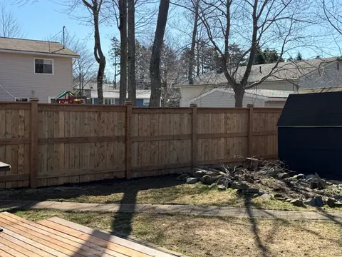 Finished wood fence across a backyard