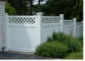 White PVC vinyl fence beside landscaping